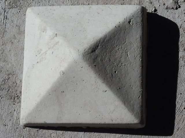A pyramid-shaped concrete pole cap for finishing fence posts.
